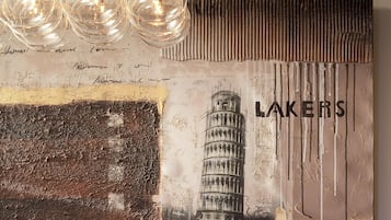 Una pared con textura, vista parcial de un edificio que recuerda a la Torre de Pisa, y la palabra