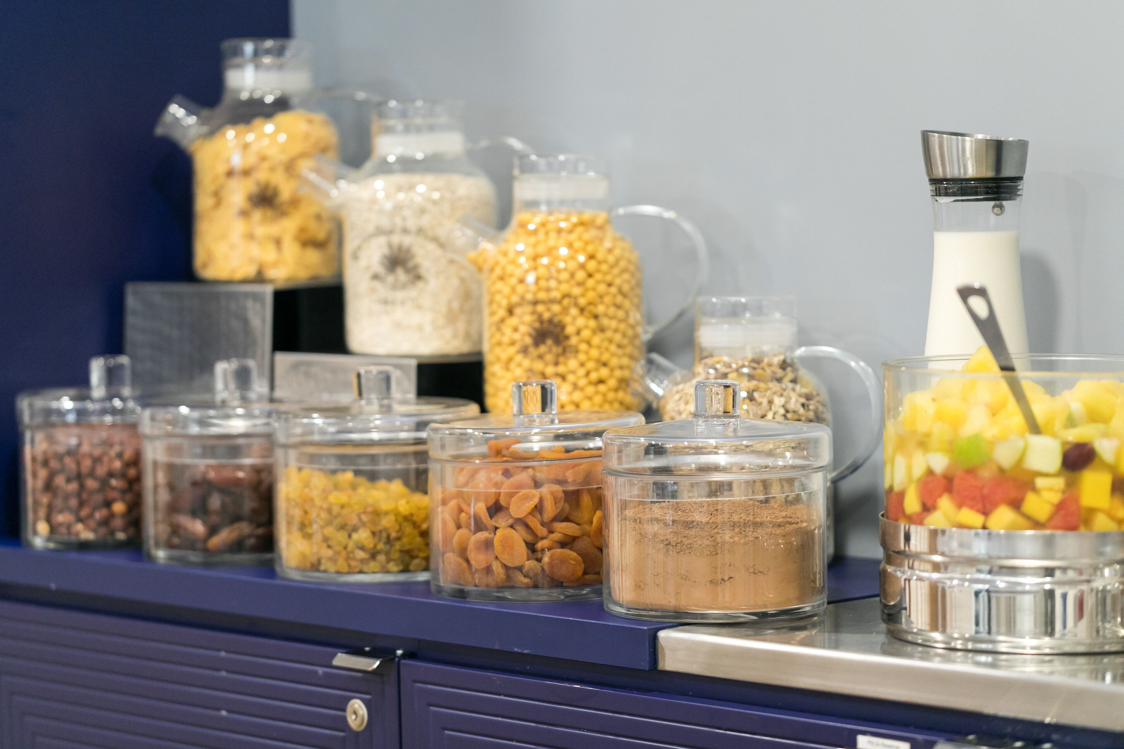 A buffet counter with various food items in glass containers.