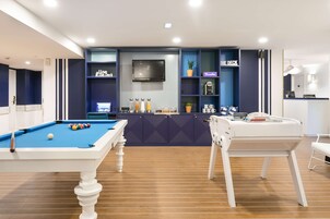 A pool table with a blue felt surface, a billiards cue, and a single white ball.