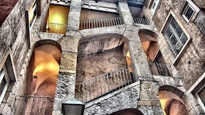 A multi-level stone building with arched staircases and balconies. - Hotel Charlemagne By HappyCulture  (Lyon)
