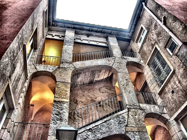 Un edificio de piedra de varios niveles con escaleras abovedadas y balcones.