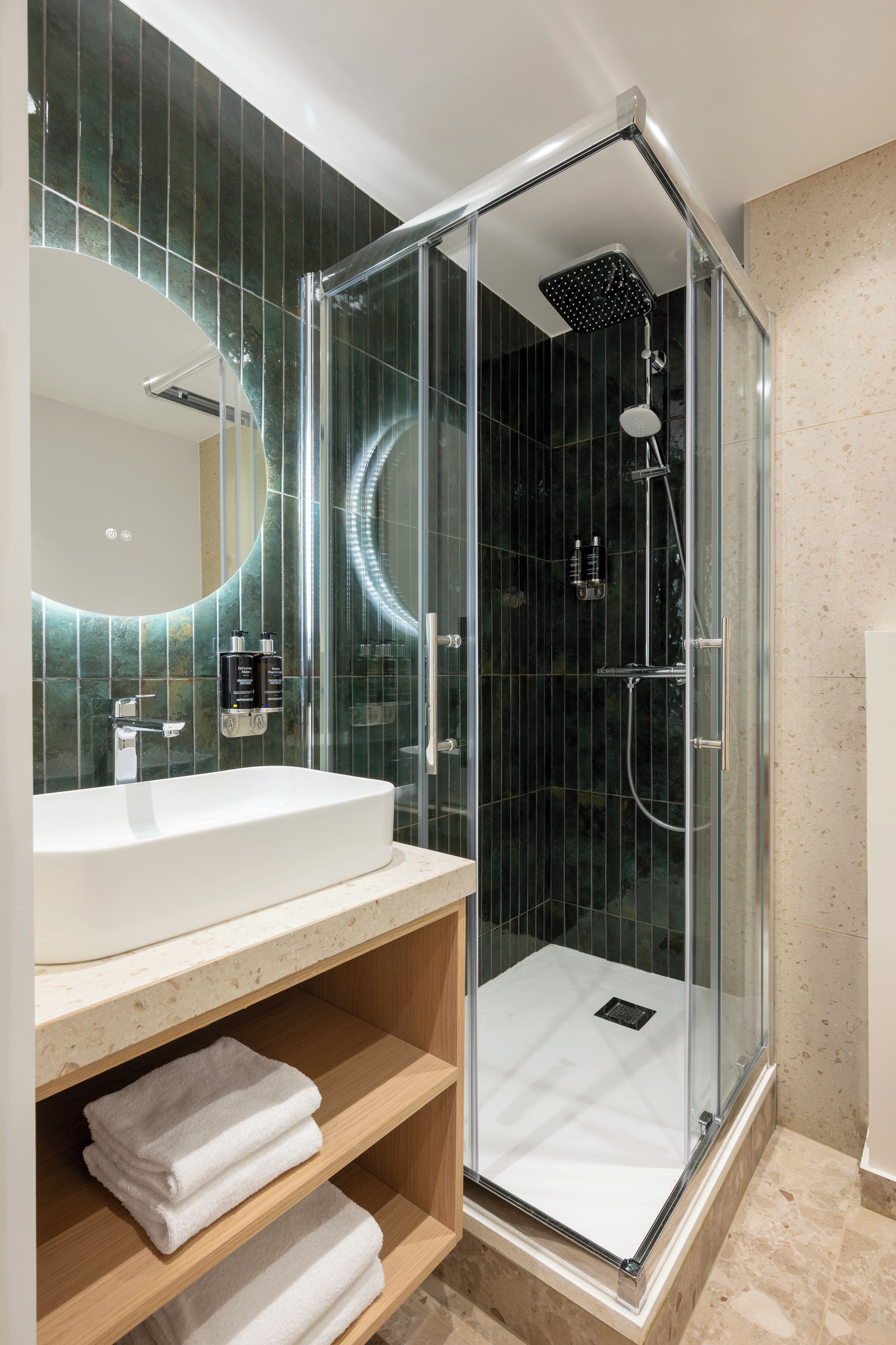 A modern bathroom with a glass-enclosed shower, a white sink, and a mirror above it.