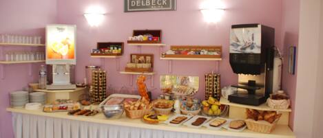 A buffet setup with various food items and a coffee machine.