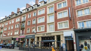 Un immeuble à plusieurs étages abritant un café au rez-de-chaussée appelé « Le Patio » et un hôtel-boutique nommé « Cathédrale ».