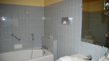 A bathroom with a bathtub, a sink, and a mirror.