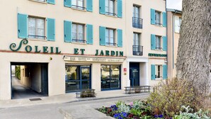 Ein Hotel mit Bar und Restaurant im Erdgeschoss, mit einer traditionellen Fassade und blauen Fensterläden.