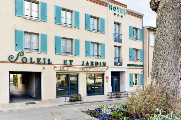 A hotel with a bar and restaurant on the ground floor, featuring a traditional facade with blue shutters. - Soleil et Jardin (Solaize)