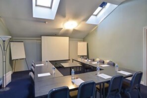 Meetings and presentations come alive in this well-equipped conference room with a projector screen and ample natural light.