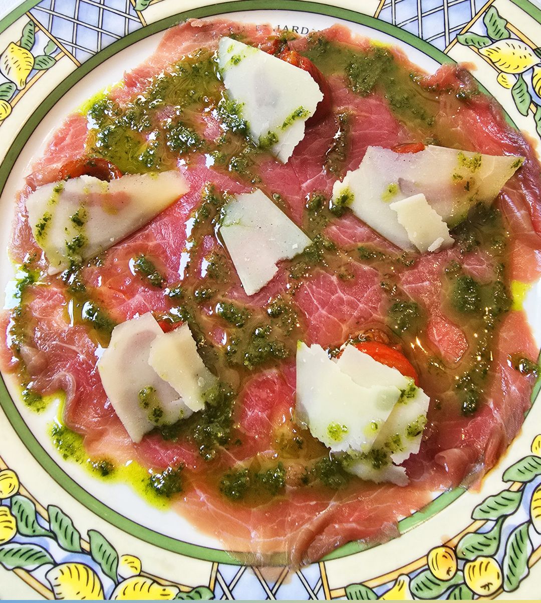 A plate of Carpaccio de boeuf, coques de parmesan, and poivrons confits, pistou.