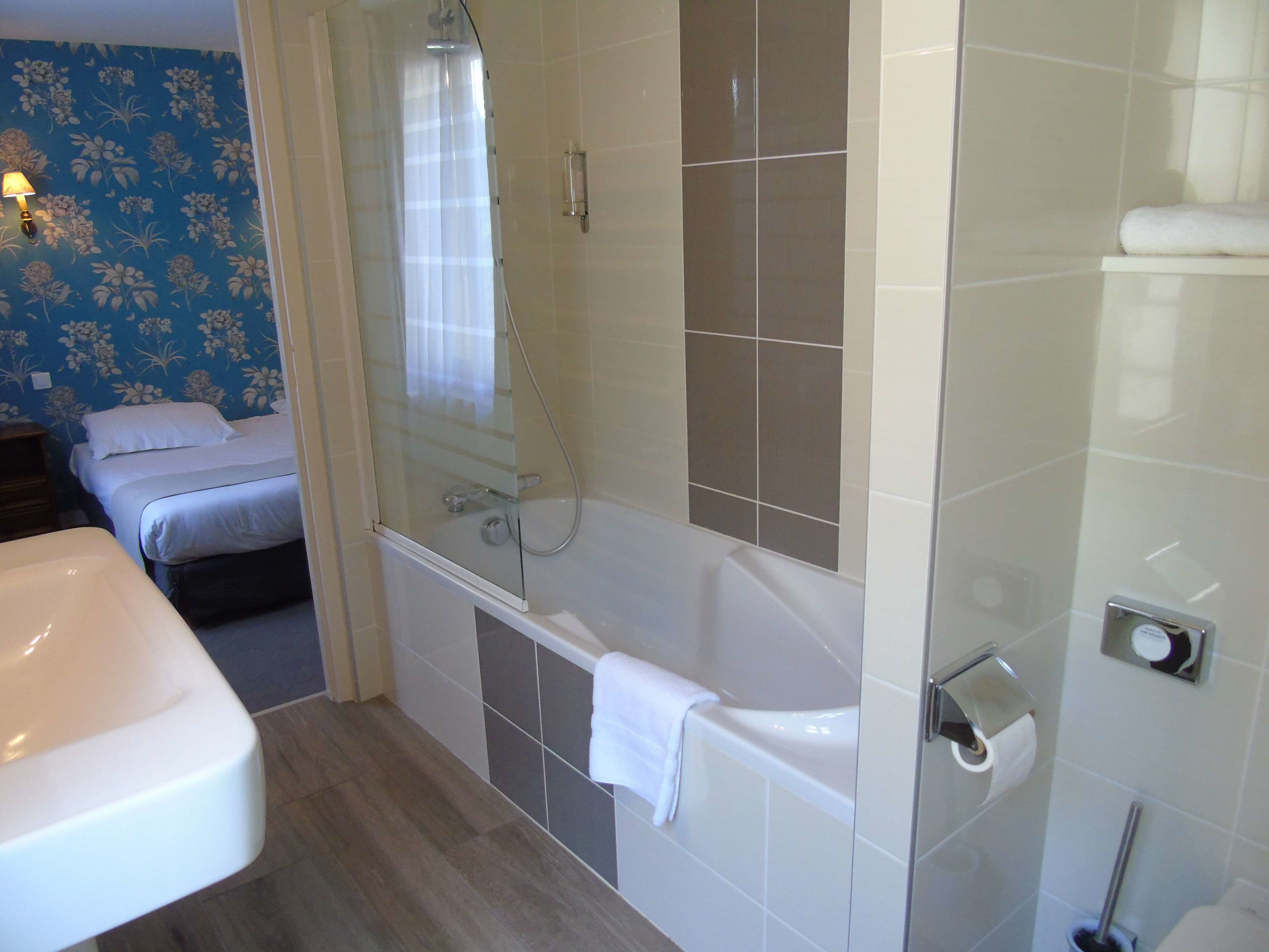 A bathroom with a bathtub, a shower, a sink, and a toilet.