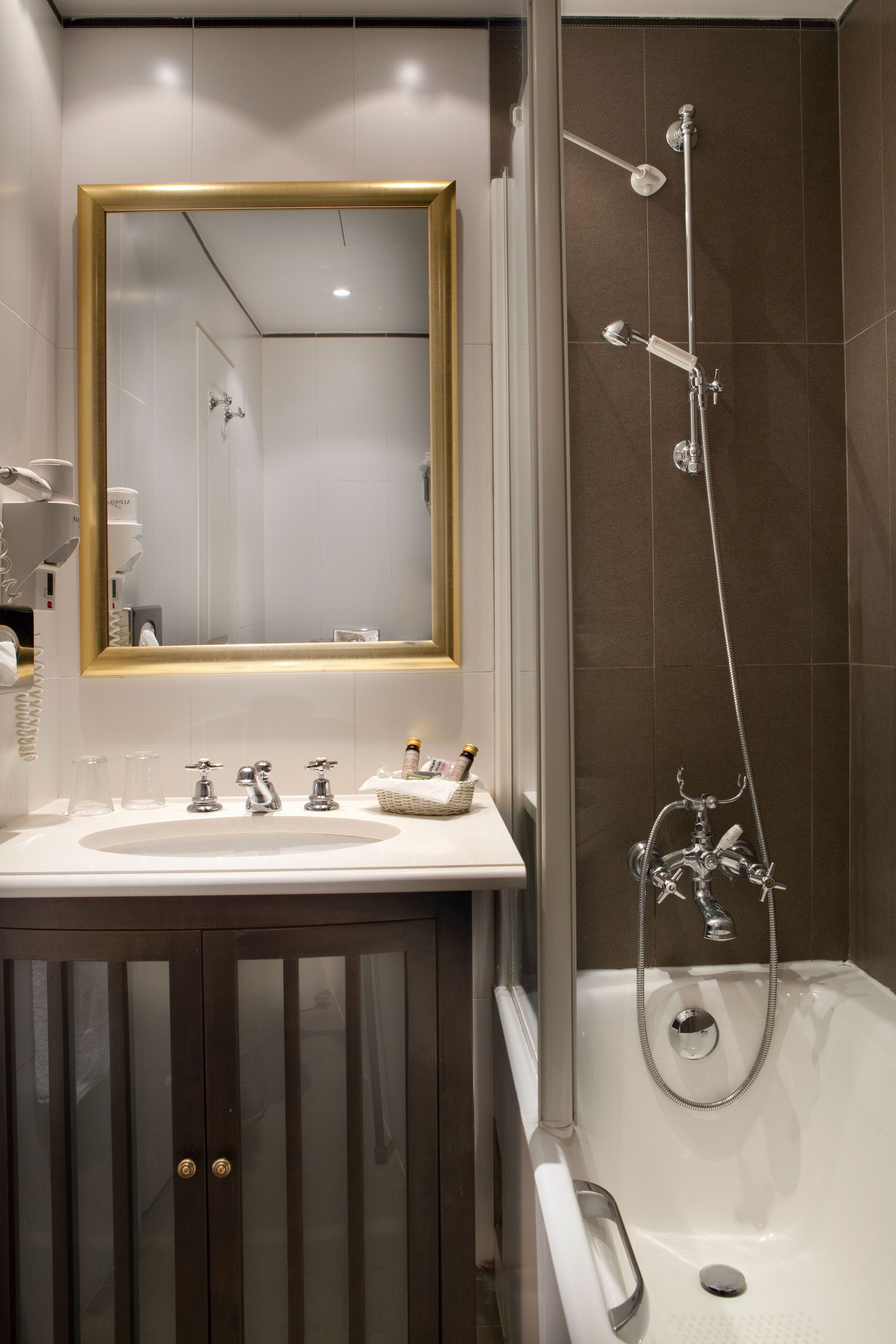 Une salle de bain moderne avec un grand miroir, une baignoire et un meuble-lavabo.