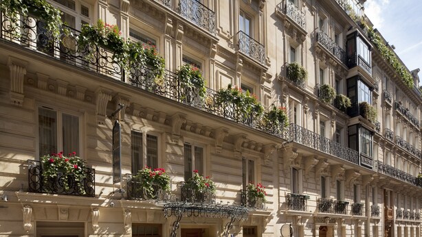 A multi-story building with ornate balconies, large windows, and decorative iron railings.