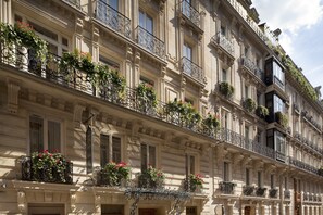 A multi-story building with ornate balconies, large windows, and decorative iron railings.