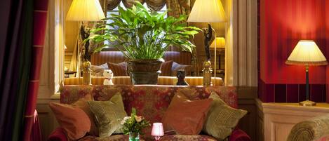 A cozy room with a sofa, a round table, and a potted plant.