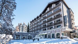 Un hotel de varios pisos con diseño moderno, que cuenta con balcones y ventanas amplias.