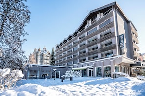 A multi-story hotel with a modern design, featuring balconies and large windows.