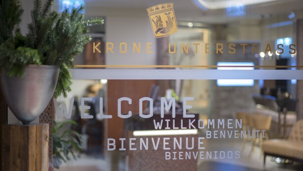 Una zona de recepción con un letrero de bienvenida y un logotipo encima.