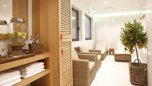 A modern bathroom with wicker furniture, a large mirror, and a potted orange tree. - Parkhotel Wittekindshof Dortmund (Dortmund)