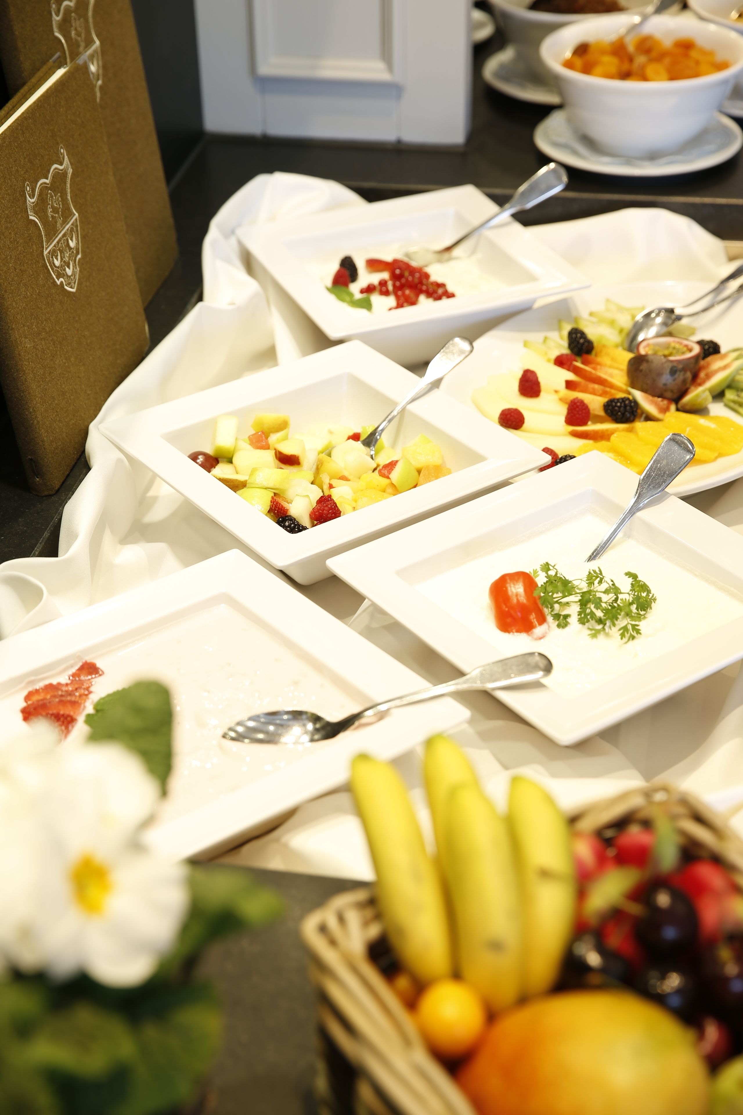 A buffet table with various dishes and fruits.
