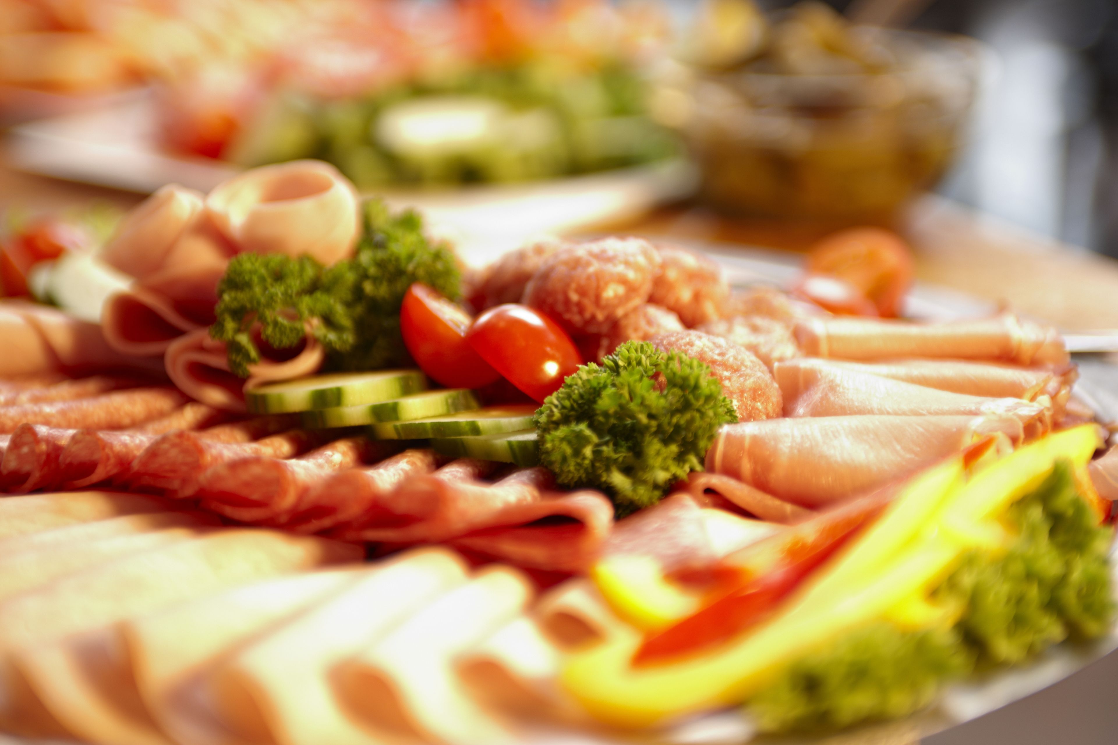 Una tabla de fiambres con carnes, quesos y verduras variadas.