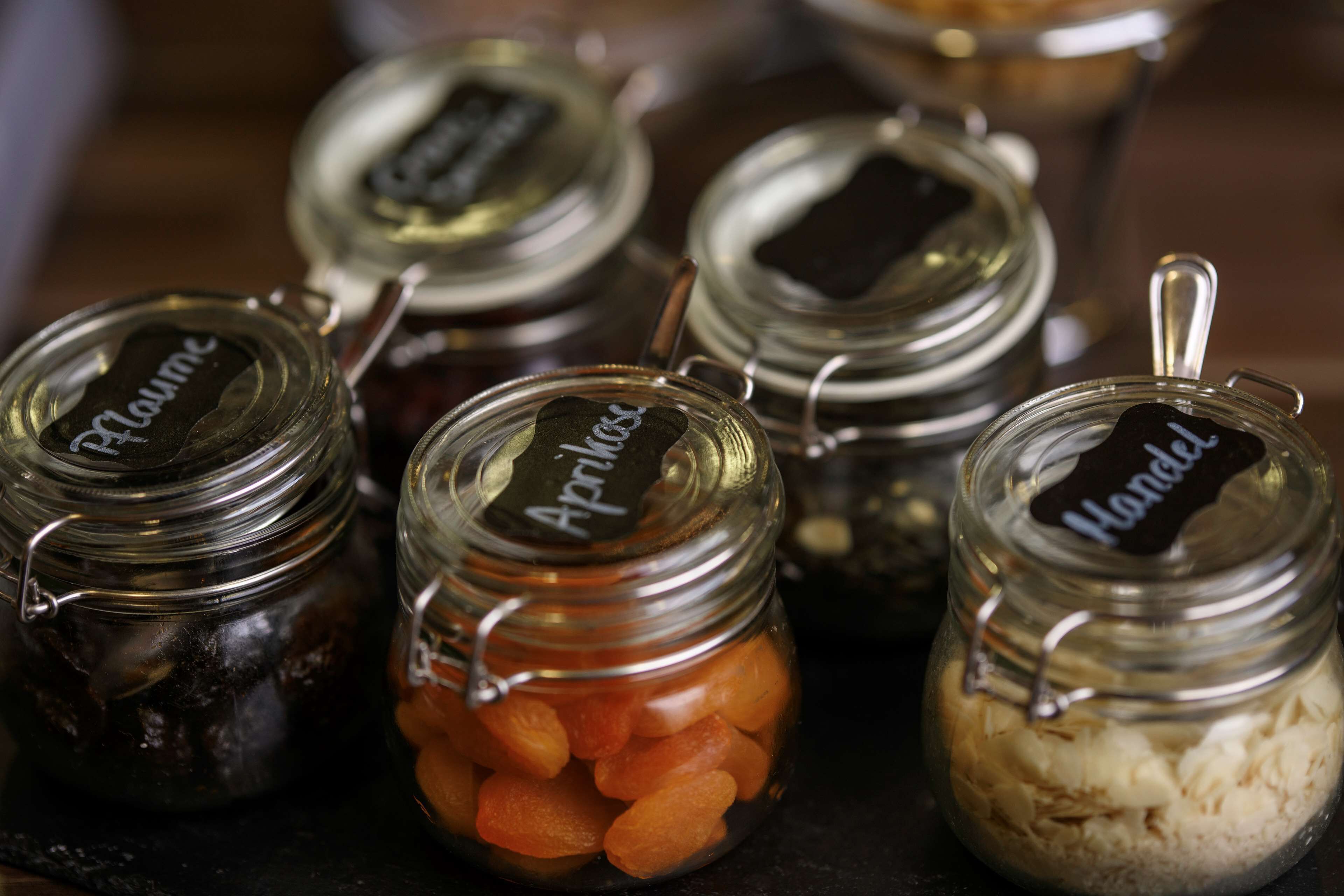 Several glass jars with metal lids, each labeled with a name.