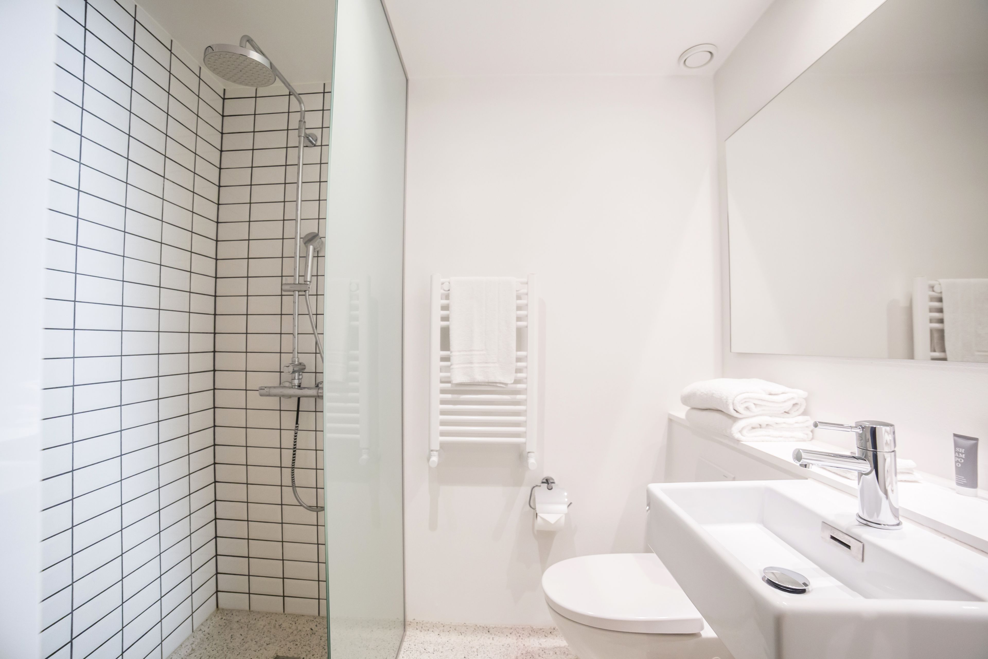 Un baño moderno con ducha, inodoro y lavamanos.
