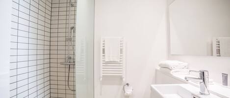 Un baño moderno con ducha, inodoro y lavamanos.
