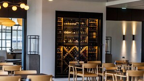 Un intérieur moderne agrémenté d’une cave à vin, de chaises et de tables en bois.