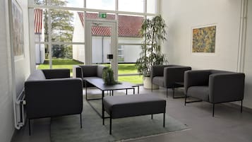 Een modern interieur met een zithoek, een groot raam en een plant in pot.