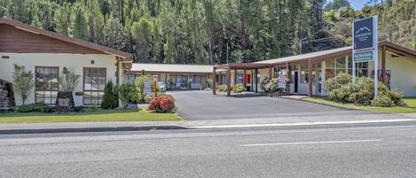 Un motel con zona de estacionamiento techada y un letrero que dice Gold Rush Inn.