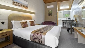 A modern hotel room with a large bed, a desk, and a chair. - Gold Rush Inn (Queenstown)