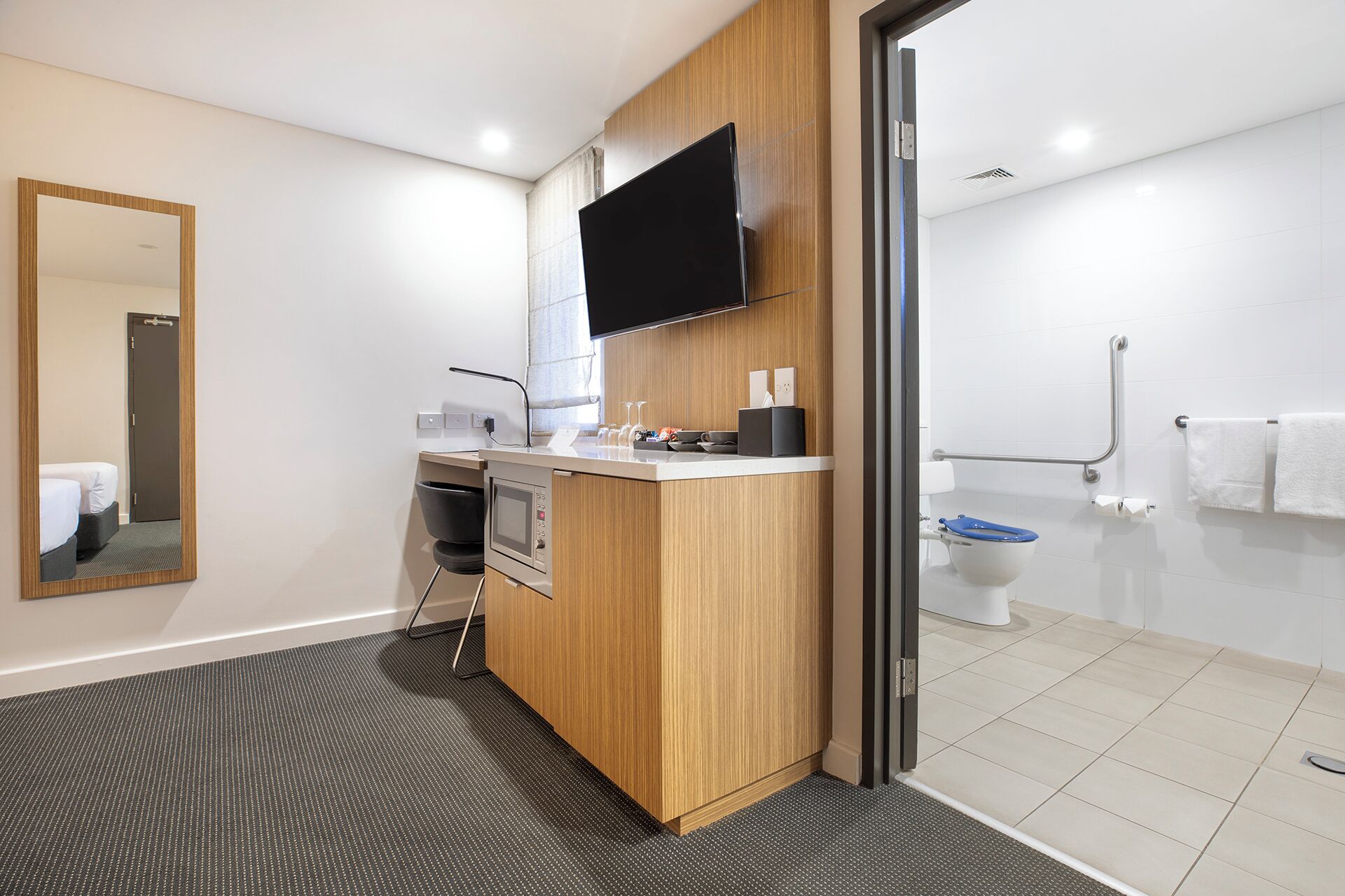 A modern bathroom with a shower, toilet, and sink.
