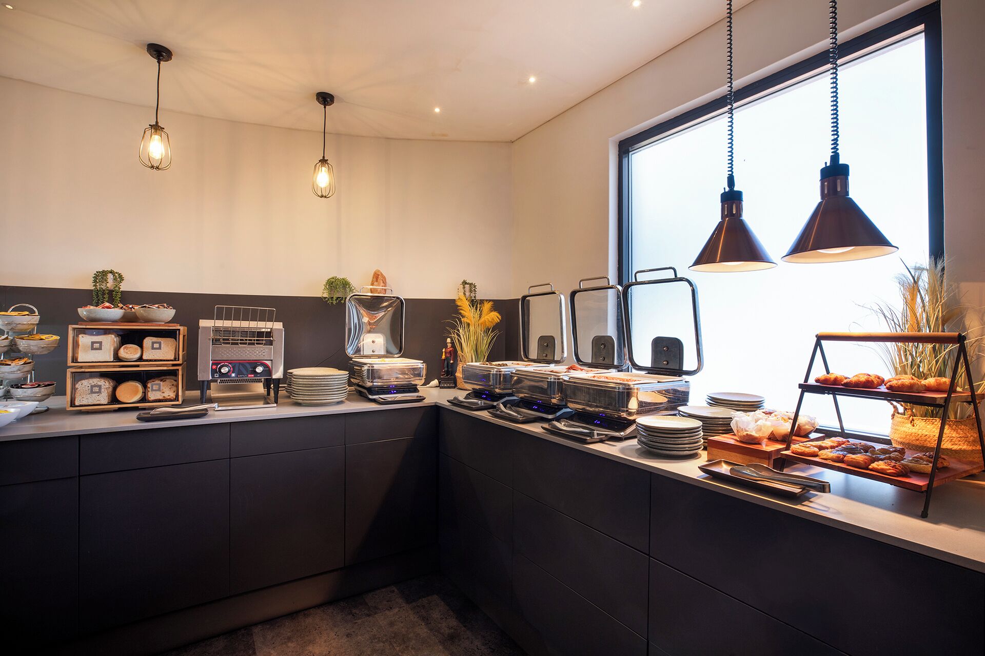 Una cocina moderna con horno empotrado, cafetera y diversos alimentos sobre la encimera.