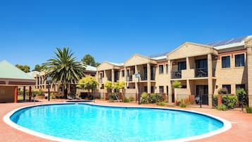 Una piscina al aire libre, tumbonas