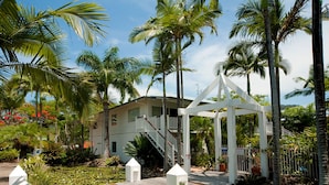 A white gazebo with a wooden deck, surrounded by lush greenery and a pond with lily pads. - Mango House Resort (Jubilee Pocket)