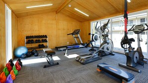 A gym with exercise equipment, a rack of dumbbells, and a variety of colorful shoes. - Rydges Armidale (Armidale)