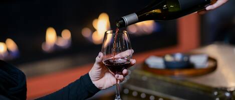 A person pouring wine into a glass.