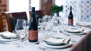 A table set for a meal with wine glasses, plates, and cutlery. - Rydges Armidale (Armidale)