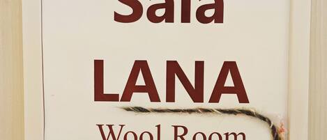 A framed sign with the text "Sala LANA Wool Room".