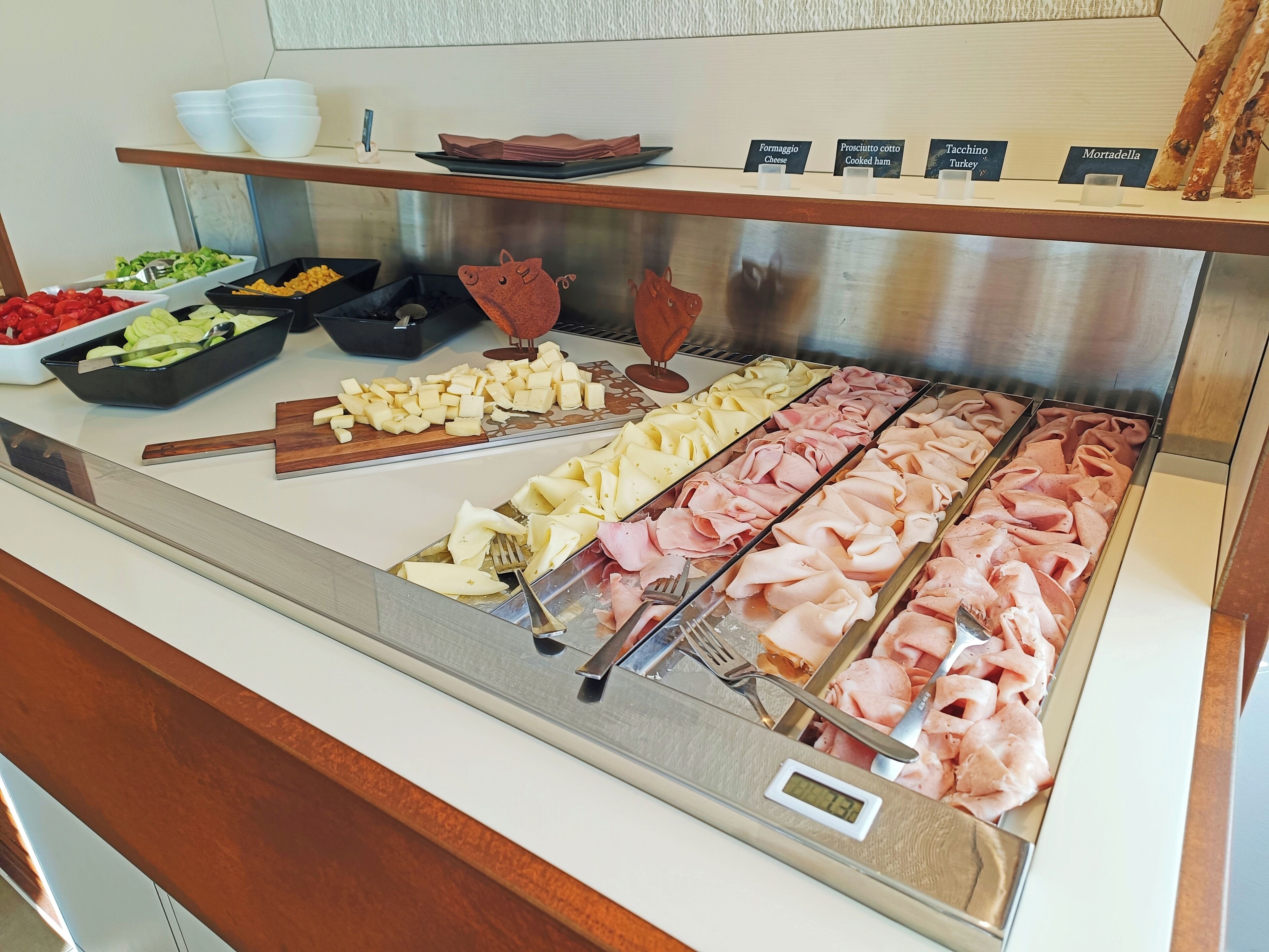 A buffet with various food options including cheese, ham, and cooked ham.