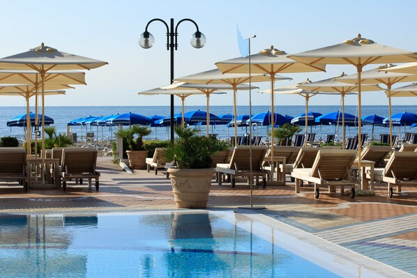 Piscine extérieure, parasols de plage, chaises longues