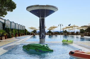 Una piscina al aire libre, sombrillas, tumbonas