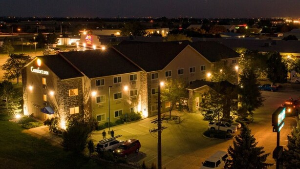 A Comfort Inn with a stone facade, multiple windows, and a parking lot. - Comfort Inn Fort Collins North (Fort Collins)