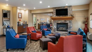 A hotel lobby with seating areas, a fireplace, a television, and a coffee station. - Comfort Inn Fort Collins North (Fort Collins)