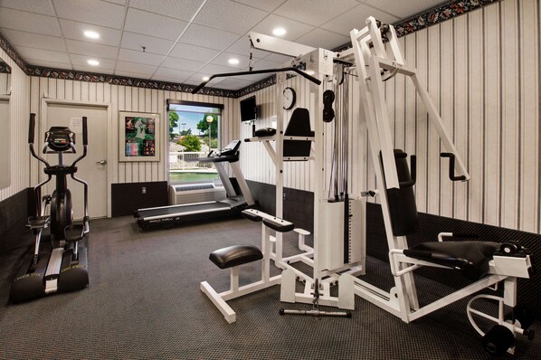 A gym with cardio machines, weight training equipment, and a treadmill.