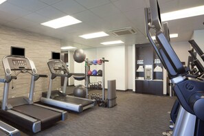 Un gimnasio con cintas de correr, bicicletas estáticas y diversos equipos de ejercicio.