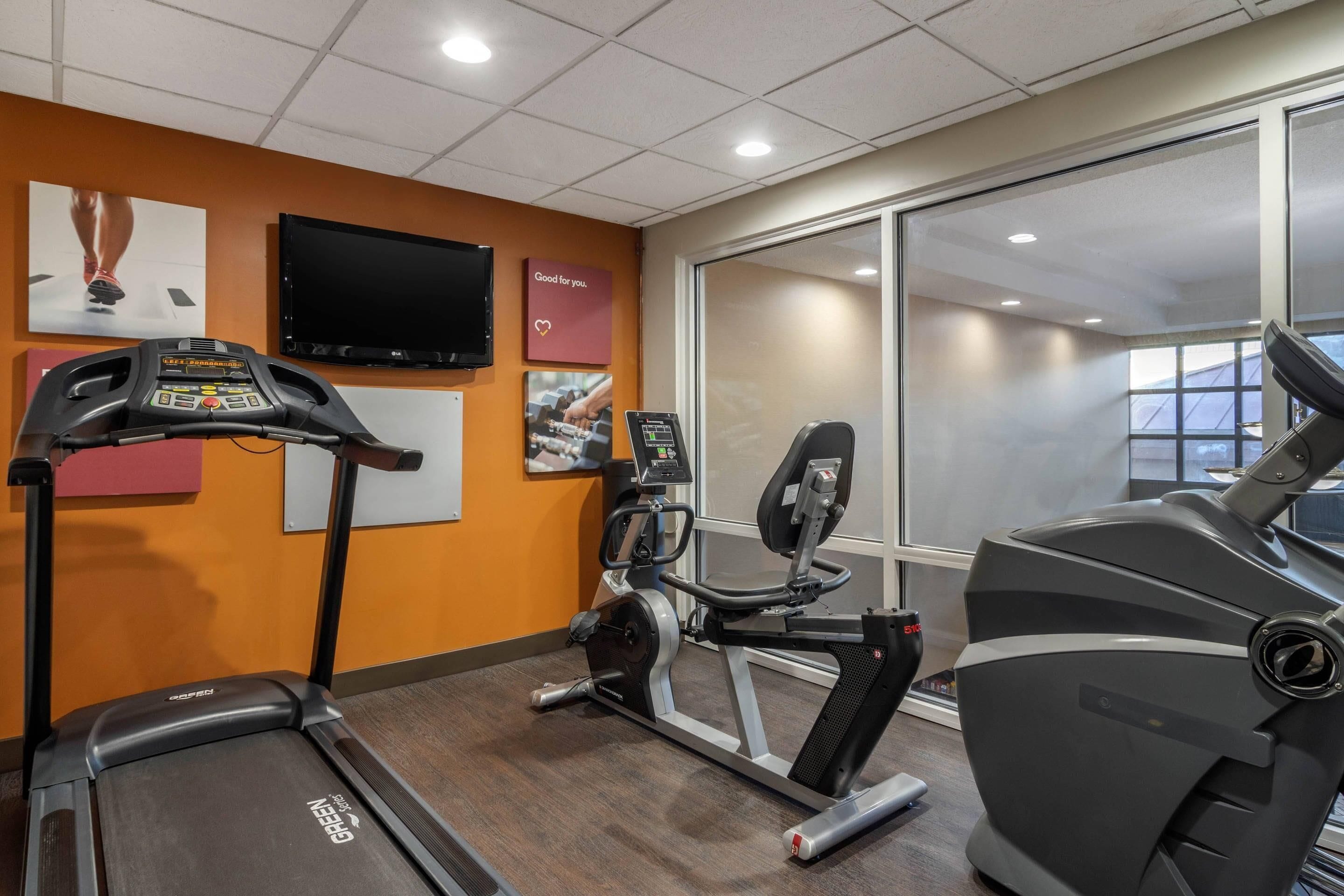 A gym with treadmills, an elliptical, and a stationary bike.