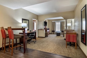 A hotel room with a desk, two chairs, a television, a large mirror, and a window with curtains. - Comfort Suites Woodstock - Atlanta North (Woodstock)
