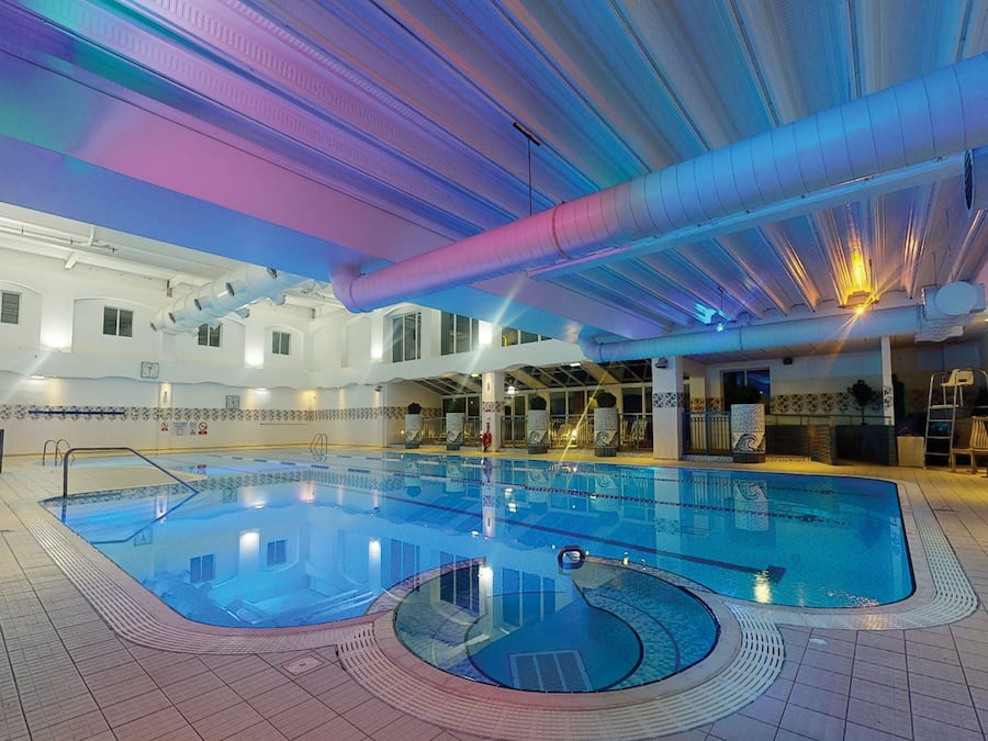 Een binnenzwembad en ligstoelen