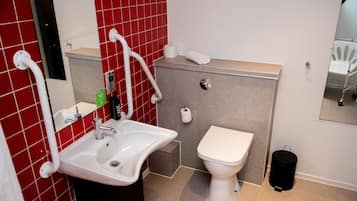 A modern bathroom with a white sink, a toilet, and a mirror.